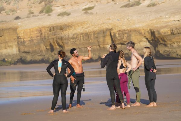 Surfanfänger und Surfcoach am Strand von Marokko